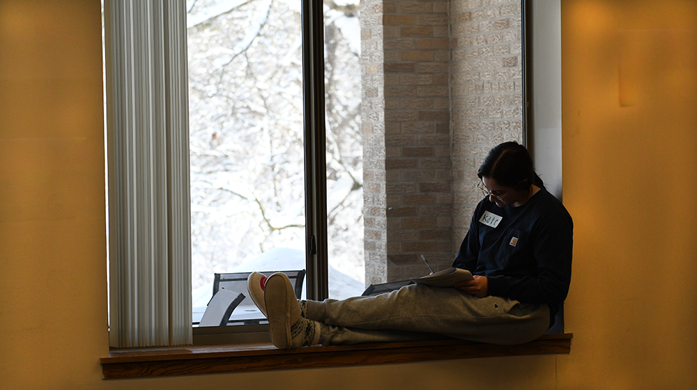 Student by window, writing